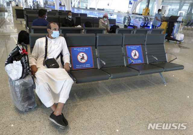 28일(현지시간) 사우디아라비아 지다의 킹압둘아지즈 국제공항에서 코로나19 확산을 막기 위해 마스크를 쓴 한 승객이 사회적 거리 두기가 표시된 의자에 앉아 탑승을 기다리고 있다. 사우디 정부는 지난 6월부터 국내 여행 제한을 완화했으며 오는 29일 시작하는 하지(Hajj) 정기순례는 자국 거주자 1만명만 제한적으로 허용한다고 밝혔다. (출처: 뉴시스)