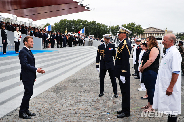 [파리=AP/뉴시스] 에마뉘엘 마크롱 프랑스 대통령이 프랑스의 32만명 방문 요양보호사들을 위해 1억6000만 유로(약 2240억원)의 급여를 추가로 지급하겠다고 4일(현지시간) 밝혔다. 사진은 지난달 14일 프랑스 혁명기념일 행사에 참석한 의료진을 향해 감사 인사를 보내는 마크롱 대통령의 모습. 2020.8.5.