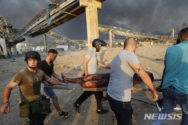 대폭발이 일어난 레바논 베이루트 항구에서 4일 시민들이 부상자를 들것에 실어 옮기고 있다. (출처: 뉴시스)