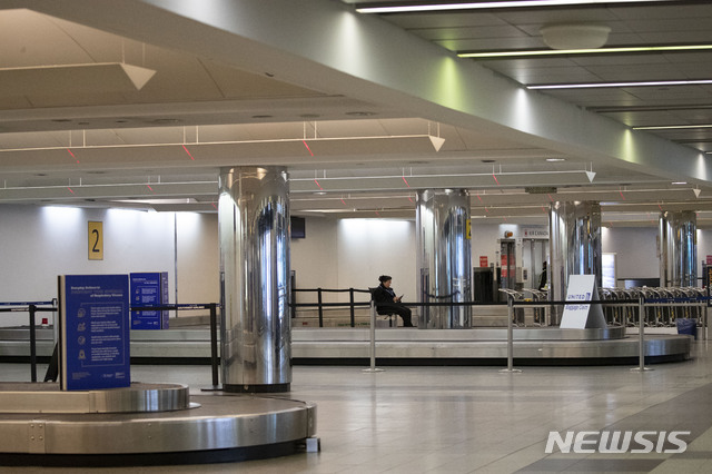 지난 3월 21일(현지시간) 미국 뉴욕의 라과디아 공항 수하물 찾는 곳에 이곳 직원이 혼자 앉아 있다. 미 연방항공청(FAA)은 롱아일랜드의 지역 항공 교통 관제센터에서 훈련받은 한 관제사가 신종 코로나바이러스 감염증(코로나19) 양성 반응을 보인 후 뉴욕 시내 공항을 잠정 폐쇄했다. (출처: 뉴시스)