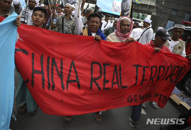 27일(현지시간) 인도네시아 자카르타 주재 중국 대사관 앞에서 무슬림 남성들이 현수막을 들고 시위를 벌이고 있다(출처: 뉴시스)