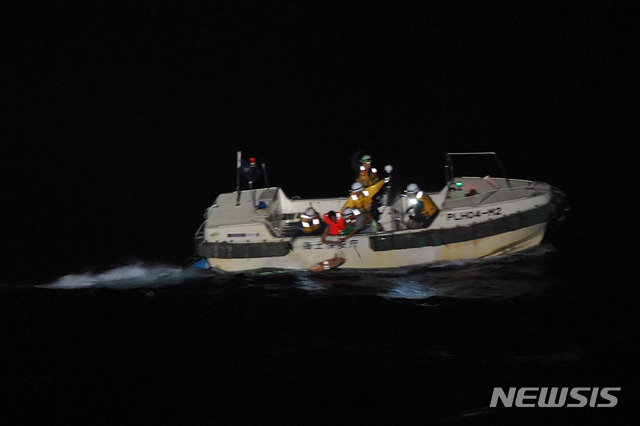 [AP/뉴시스] 2일 저녁 일본 해안경비대 구조선이 소 화물선 침몰 후 표류중이던 필리핀인 선원(빨간옷)을 구해 달리고 있다.