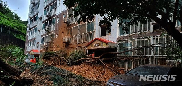 [거제=뉴시스] 제10호 태풍 ‘하이선’이 쏟아부은 폭우로 7일 오전 경남 거제시 문동동 한 아파트 앞 절개지가 무너져 토사와 나무가 아파트 입구를 막고 있다.