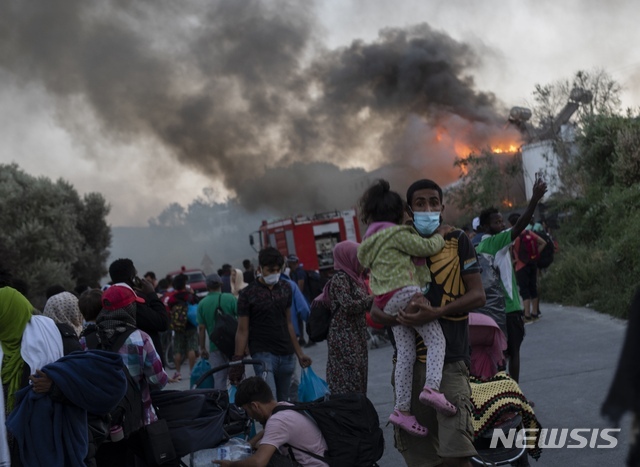 화재로 전소된 그리스 난민 캠프를 벗어나고 있는 난민들. [그리스=뉴시스/AP]