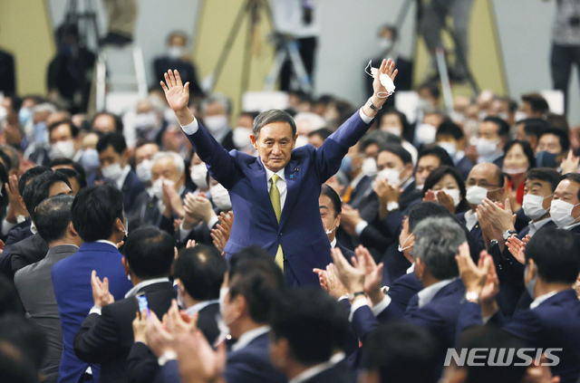 스가 요시히데 일본 자민당 총재가 14일 일본 도쿄의 한 호텔에서 열린 집권 자민당 총재 선거에서 당선이 결정된 후 손을 들어 인사하고 있다. 스가는 오는 16일 임시 국회에서 일본 총리로 선출될 것으로 전망된다. (출처: 뉴시스)