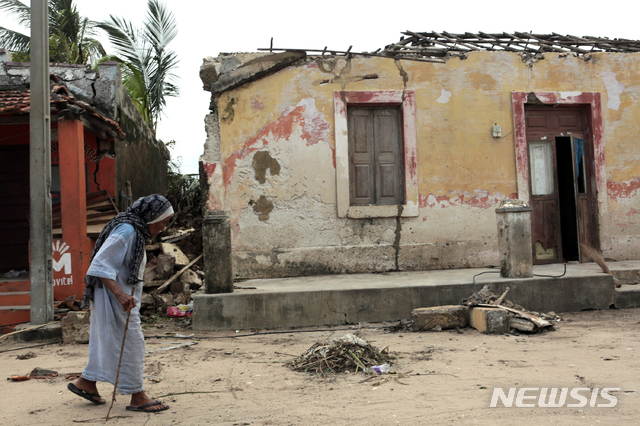 【펨바(모잠비크)=AP/뉴시스】지난달 25일(이하 현지시간) 모잠비크를 또다시 강타한 사이클론으로 피해가 속출한 가운데 1일 펨바 북쪽 이보 섬에서 한 할머니가 파손된 가옥 앞을 지나고 있다.
