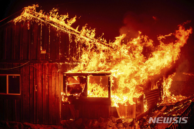 [뷰트카운티=AP/뉴시스]9일(현지시간) 미 캘리포니아주 뷰트 카운티의 베리 크리크 지역에 낙뢰로 촉발된 산불 '베어 파이어'가 번지면서 한 가정집이 불에 타고 있다. 캘리포니아 전역에서 계속되고 있는 산불이 심한 강풍을 타고 폭발적으로 확산, 미국 서부 전역으로 확산하고 있다.