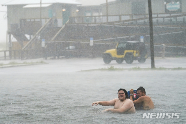 15일(현지시간) 미 플로리다주 펜서콜라 비치의 나바르비치 주차장이 허리케인 샐리의 영향으로 침수된 가운데 주민들이 물놀이를 하고 있다(출처: 뉴시스)