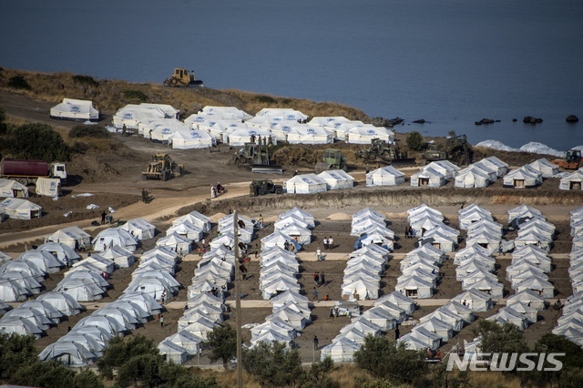 [그리스=뉴시스/AP] 17일(현지시간) 그리스 북동쪽 레스보스 섬의 카라 테페에 있는 새로운 임시 난민 캠프에 이주민들이 모여들면서 기계들이 작동하고 있다. 그리스 레스보스섬에서는 과밀 수용소로 악명이 높았던 모리아 수용소가 화재로 전소됐다. 5천명 이상의 망명 신청자들이 집을 잃었다.