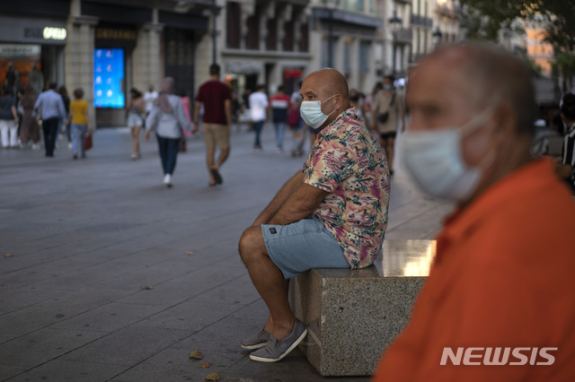 [바르셀로나=AP/뉴시스]15일(현지시간) 스페인 바르셀로나 시내에 마스크를 쓴 남성들이 앉아 있다.