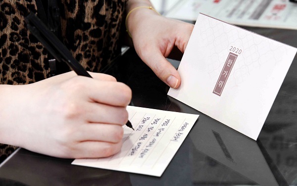 21일 고객이 서울 등촌동 홈플러스 강서점에서 추석선물세트를 구매하며 제공된 편지지에 직접 작성한 손편지를 봉투에 담고 있다. (제공: 홈플러스)