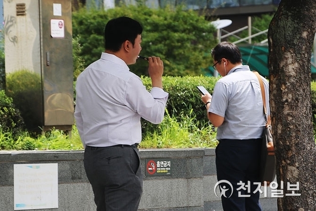 [천지일보=이예진 기자] 흡연금지 팻말이 붙어있는 곳 앞에서 담배 피우고 있는 모습.  ⓒ천지일보 2018.8.31