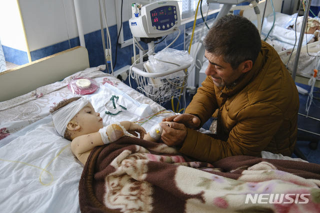28일(현지시간) 아제르바이잔과 아르메니아의 분쟁 지역인 나가르노카라바흐의 수도 스테파나케르트의 병원에서 한 남성이 포격을 당한 자녀와 대화를 나누고 있다. (출처: 뉴시스)