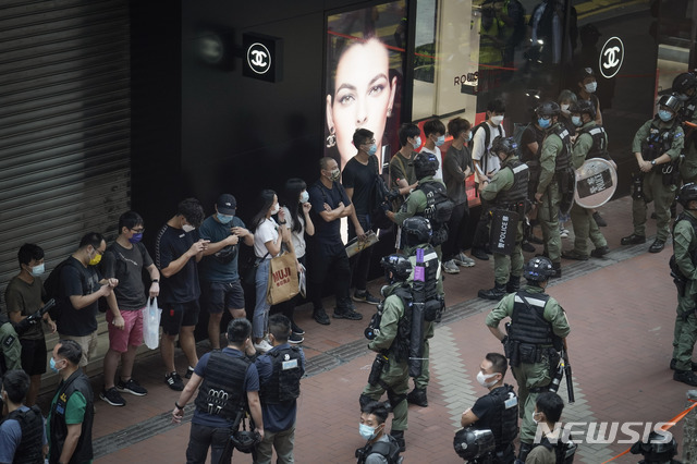 [홍콩=AP/뉴시스] 홍콩 경찰이 중국 국경절인 1일 코즈웨이베이에서 보행자를 검문하고 있다. 홍콩 경찰은 1일 신종 코로나바이러스 감염증(코로나19)으로 대규모 집회가 금지됐음에도 불구하고 중국 국경절을 맞아 민주화 구호를 외치며 거리에 몰려든 최소 60명의 시위대원들을 불법 집회 혐의로 체포했다. 2020.10.1