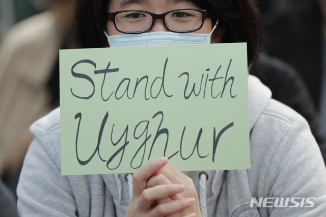 홍콩의 한 시위자가 위구르족을 지지하는 내용의 피켓을 들고 있다. (출처: 뉴시스)