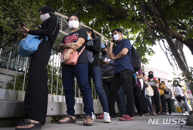 [방콕=AP/뉴시스]지난 6월 4일(현지시간) 태국 방콕의 사회보장국 앞에 신종 코로나바이러스 감염증(코로나19) 예방을 위해 마스크를 쓴 시민들이 실업급여를 청구하기 위해 줄을 서서 순서를 기다리고 있다.