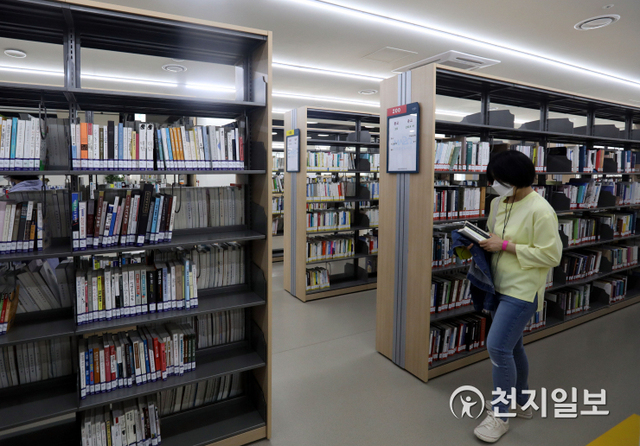 [천지일보=남승우 기자] 생활 속 거리두기가 시작된 6일 오전 서울 마포구 마포중앙도서관에서 한 시민이 마스크를 쓴 채 책을 고르고 있다. ⓒ천지일보 2020.5.6