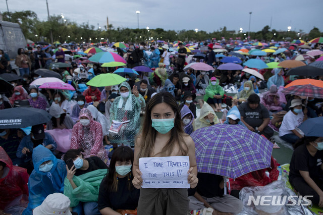 지난 19일 태국 방콕에서 한 민주화 시위 참가자가 플래카드를 들고 있다. (출처: 뉴시스)