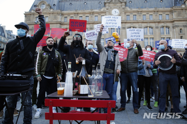 13일(현지시간) 프랑스 파리의  생라자르 역 앞에서 술집 주인들과 직원들이 정부의 코로나19 확산 예방을 위한 술집과 실내 스포츠 시설 폐쇄에 반대하며 손팻말을 들고 시위하고 있다(출처: 뉴시스)