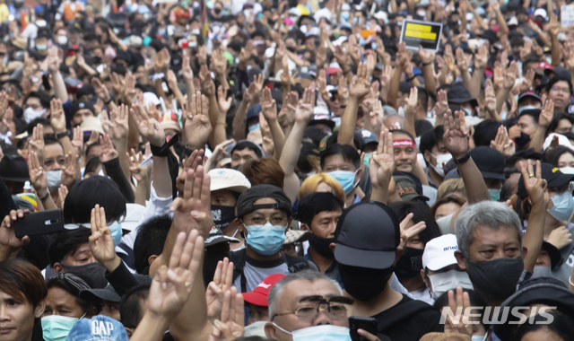 14일(현지시간) 태국 방콕의 민주주의 기념탑 근처에서  반정부 시위대가 저항의 상징인 세 손가락 경례를 하고 있다(출처: 뉴시스)