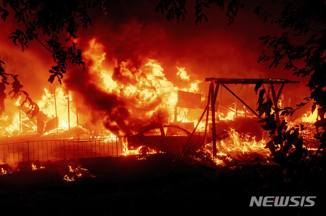 [뷰트카운티=AP/뉴시스] 지난 9월 9일(현지시간) 미 캘리포니아주 뷰트 카운티의 베리 크리크 지역에 낙뢰로 촉발된 산불 '베어 파이어'가 번지면서 한 가정집과 자동차에 불이 옮겨 붙고 있다.