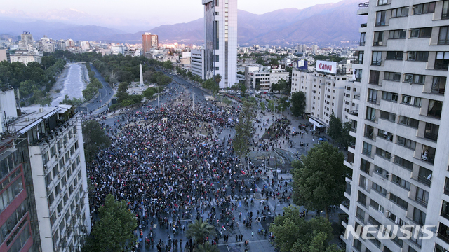 [산티아고=AP/뉴시스]칠레 개헌 국민투표가 열리는 25일(현지시간) 칠레 산티아고의 이탈리아 광장에 반정부 시위대가 모여 있다.