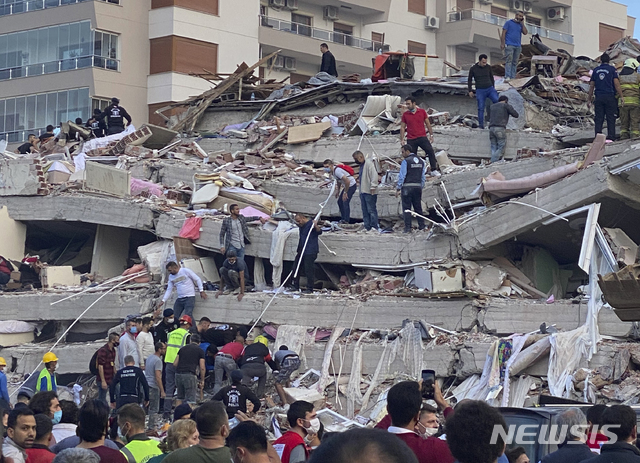 [이즈미르=AP/뉴시스]30일(현지시간) 터키 해안과 그리스 사모스섬 사이 에게해에서 발생한 규모 7.0의 지진으로 인근 도시 이즈미르에서 건물이 무너져 구조대가 잔해에 갇힌 사람들을 수색하고 있다.