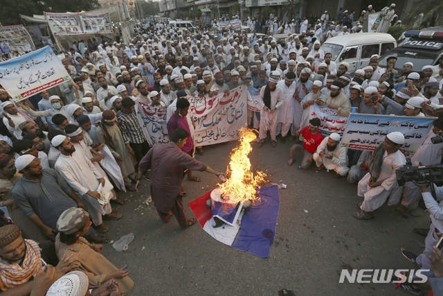 지난달 31일(힌지시간) 파키스탄 카라치에서 한 종교 단체 지지자들이 프랑스 대통령에 대한 항의 시위 도중 프랑스 국기를 불태우고 있다. (출처:AP/뉴시스)
