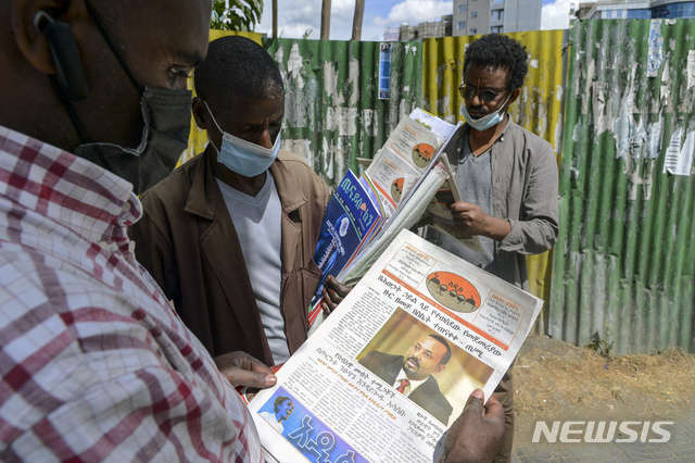 지난 11월 7일 에티오피아 내전  뉴스를 신문에서 보고 있는 아디스 아바바 시민들. 아비 아흐메드 총리의 사진이 1면에 실려있다. (출처: 뉴시스)