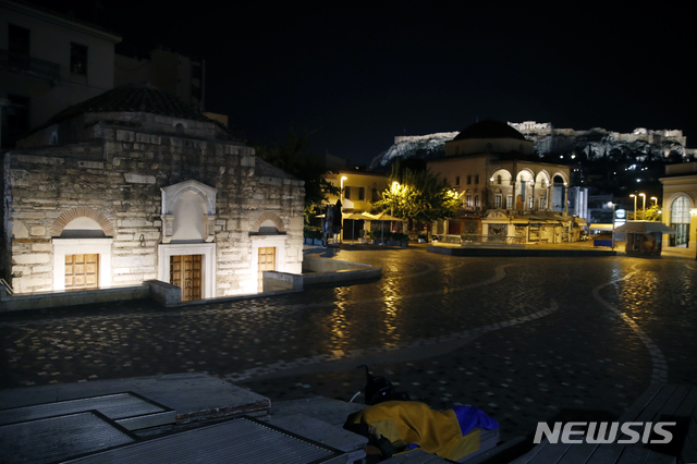 코로나19 방역을 위해 야간 통행금지가 실시된 그리스 아테네시의 모나스티라키 광장에서 한 노숙자가 11월 13일 잠을 자고 있다.  (출처:AP/뉴시스)