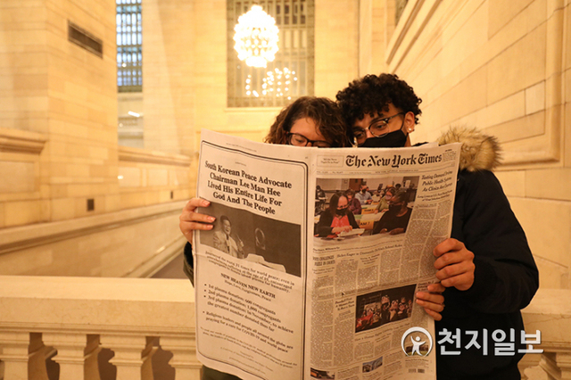 미국 뉴욕에서 엘비스(오른쪽)가 14일(현지시간) 뉴욕타임스에 실린 신천지 완치 성도의 혈장 공여 광고를 보고 있다. ⓒ천지일보 2020.11.16 (제공: 종교간지도자들과평화단체들의연합)