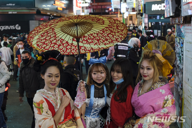 10월 31일 저녁 일본 도쿄의 시부야 거리에 핼러윈 복장을 한 여성들이 기념사진을 찍고 있다(출처: 뉴시스)