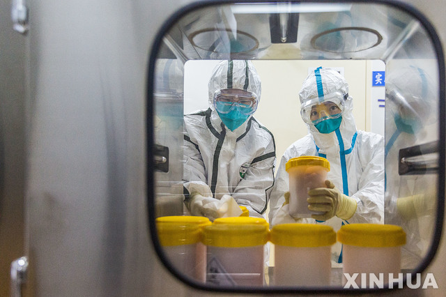 [베이징=신화/뉴시스]지난 2월25일 중국 베이징의 중국질병통제예방센터 연구실에서 직원들이 저장(浙江)성 질병통제예방센터에서 보내온 신종 코로나바이러스 변종을 검사하고 있다.