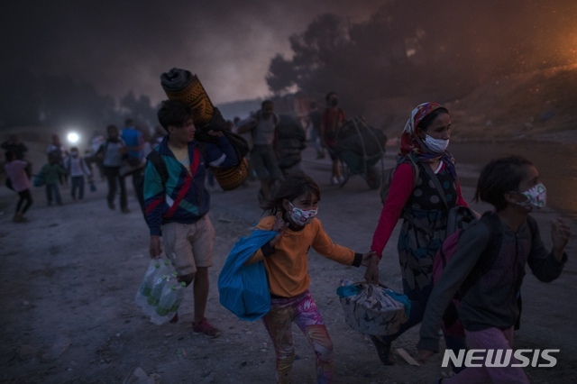 [레스보스=AP/뉴시스]9일(현지시간) 그리스 레스보스섬의 모리아 난민수용소에서 두 번째 화재가 발생해 수용 중이던 난민들이 대피하고 있다. 과밀하기로 악명 높은 이 수용소에서 8일에 이어 또다시 화재가 발생하면서 유럽의 난민 정책에 대한 비난이 다시 일고 있다. 2020.09.10.