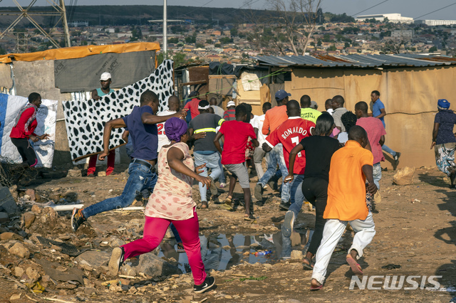 2020년 4월 20일 남아프리카공화국 요하네스버그 알렉산드라 타운 외곽에서 식량 부족에 항의하기 위해 모인 스웨틀라 정착촌 주민들이 군인이 마을에 도착하자 도망치고 있다. (출처: 뉴시스/AP)