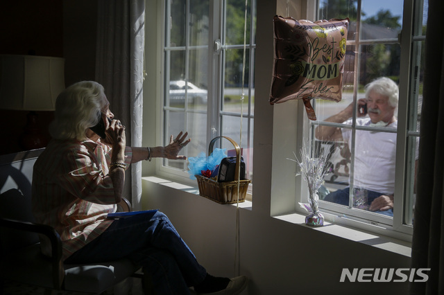 5월 10일 미국 사우스캐롤라이나 서머나에서 열린 어머니의 날 기념행사 중 메리 파예 코크란(86)이 창문 넘어 아들에게 전화로 ‘너는 내 햇살’을 불러주고 있다. (출처: 뉴시스/AP)