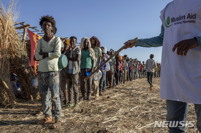 지난 12일 수단 카다리프의 움 라쿠바 난민수용소에서 에티오피아 티그라이 난민들이 음식을 배급받기 위해 길게 줄지어 서서 기다리고 있다. 에티오피아 서부 지역에서 최근 100명 이상이 숨지는 종족 학살이 벌어졌다고 에티오피아 인권위원회가 23일(현지시간) 발표했다. 위원회는 사망자 수가 앞으로 더 늘어날 것으로 우려된다고 덧붙였다. (출처:AP/뉴시스)