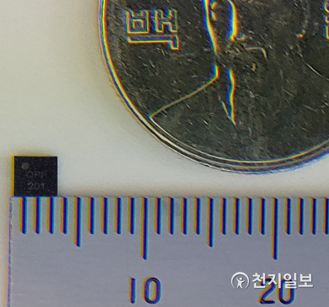 이번에 개발된 IoT 단말용 초소형 양자보안칩과 100원짜리 동전의 크기를 비교하고 있다. (제공: LG유플러스) ⓒ천지일보 2020.12.27