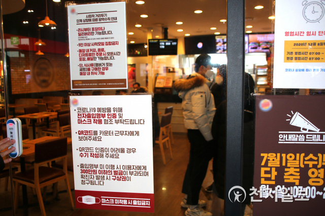 정부가 형평성 논란이 있던 패스트푸드점 등에 대한 방역 수위를 높여 매장 내 식사 외 디저트, 음료 등 취식을 금지한 가운데 29일 서울역 한 페스트푸드점 문 앞에 방역수칙이 기록된 표지가 붙어 있다. ⓒ천지일보 2020.12.29