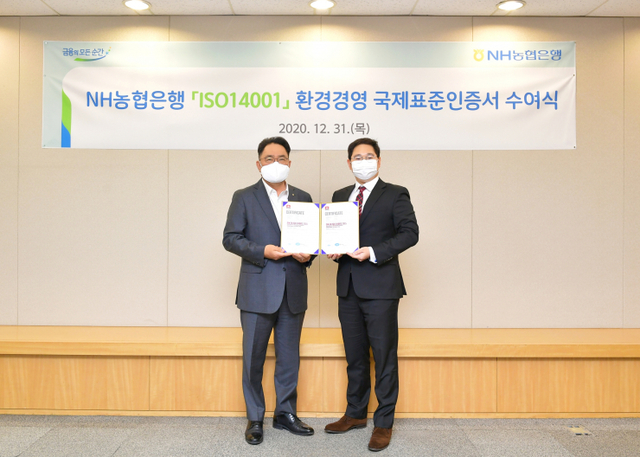 지난 12월 31일 서울시 중구에 위치한 농협은행 본점에서 NH농협은행 지준섭 농업·녹색금융부문 부행장(왼쪽)과 로열서트코리아 이권상 대표가 ISO 14001 인증서 수여식을 갖고 기념촬영을 하고 있다. (제공: 농협은행)