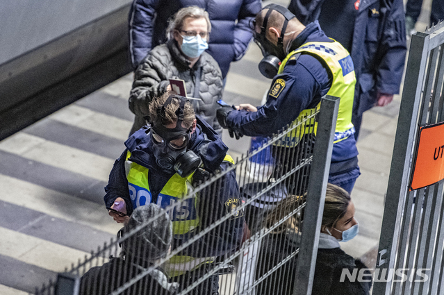 [말뫼=AP/뉴시스]지난달 22일(현지시간) 스웨덴 말뫼에 있는 힐리야역 국경 검문소에서 마스크를 쓴 스웨덴 경찰이 덴마크발 여행자들을 검문하고 있다.