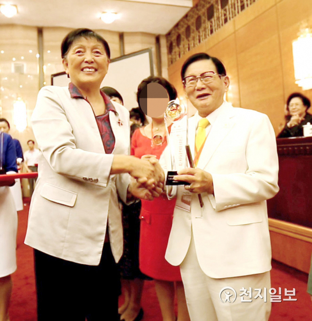 이만희 HWPL 대표가 2014년 8월 16일 장매영(張梅潁) 중국 전국정치협상회의 부주석으로부터 세계평화 사자상을 받고 있다. (제공:HWPL)