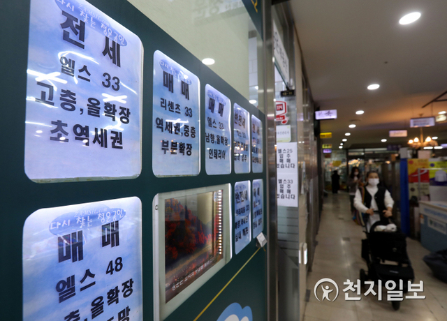 [천지일보=남승우 기자] 서울 송파구의 한 부동산 중개업소에 마련된 매매·전세·월세 관련 정보란 앞으로 시민이 지나가고 있는 모습. ⓒ천지일보 2020.11.23