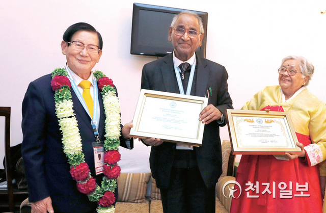 이만희 대표가 2014년 12월 12일 인도 대법관회의를 주최한 자그디시 간디(가운데)와 한복을 입은 바티 간디(오른쪽) 부부와 기념사진을 촬영하고 있다. (제공: HWPL) ⓒ천지일보 2021.1.8