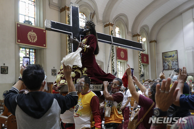 [마닐라=AP/뉴시스] 연례 '블랙 나사렛 축제'를 하루 앞둔 8일 필리핀 마닐라에 있는 산타크루즈 성당에서 가톨릭 신자들이 복제판 블랙 나사렛을 환영하고 있다. 아시아의 가장 큰 종교 행사 중 하나인 1월9일 블랙 나사렛 축제가 올해는 코로나19 대유행으로 취소됐다. 필리핀 정부는 신도들에게 각 지역사회에 있는 성당에서 행사를 치를 것을 권고했다. 2021.01.08.