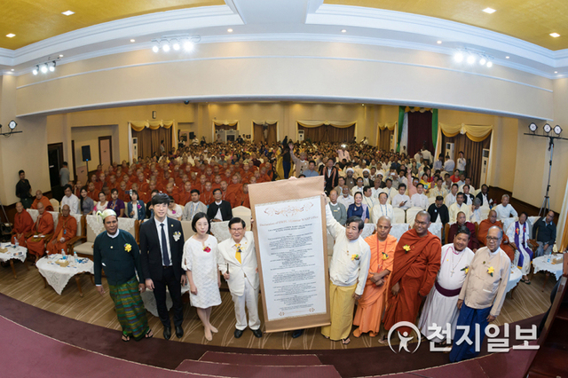 ㈔하늘문화세계평화광복(HWPL) 주최로 2018년 2월 1일 미얀마 양곤 국제사업센터에서 ‘종교 콘퍼런스’가 열린 가운데 평화를 위해 종교인들이 다짐한 선언문이 적힌 족자를 이만희 HWPL 대표(가운데에서 왼쪽)와 따니엥 YMCA 이사가 함께 들고 있다. (제공:HWPL) ⓒ천지일보 2021.1.12