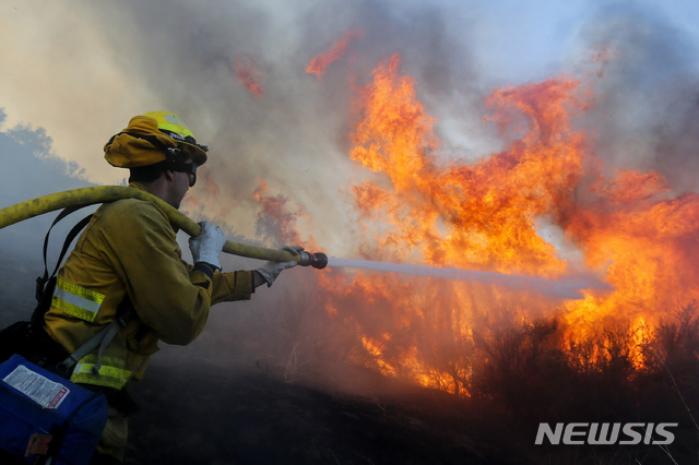 美 실버라도 산불 진압하는 소방대원[실버라도=AP/뉴시스]3일(현지시간) 한 소방관이 미 캘리포니아주 실버라도에서 발생한 '본드 파이어' 화재를 진압하고 있다.
