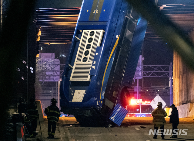 [뉴욕=AP/뉴시스]15일(현지시간) 미국 뉴욕의 브롱크스 부근에서 뉴욕시 버스 한 대가 도로 난간을 들이받고 밑으로 떨어져 위태롭게 매달려 있다. 경찰은 이 사고로 버스 운전사가 중상을 입었다고 전했다.
