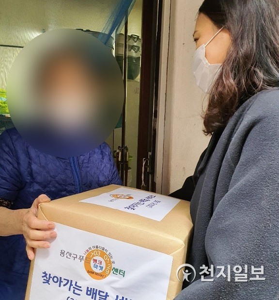 서울 용산구청 공무원이 지난 15일 푸드마켓 재가서비스 이용자에게 물품을 전달하는 모습. (제공: 용산구) ⓒ천지일보 2021.1.18