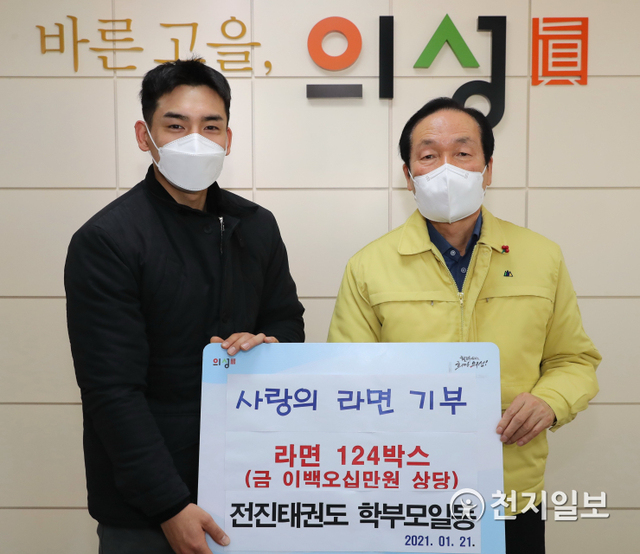 김주수 의성군수(오른쪽)가 지난 21일 사랑의 라면 124박스를 기부한 신용원 의성전진태권도 관장과 기념촬영을 하고 있다. (제공: 경북 의성군) ⓒ천지일보 2021.1.25